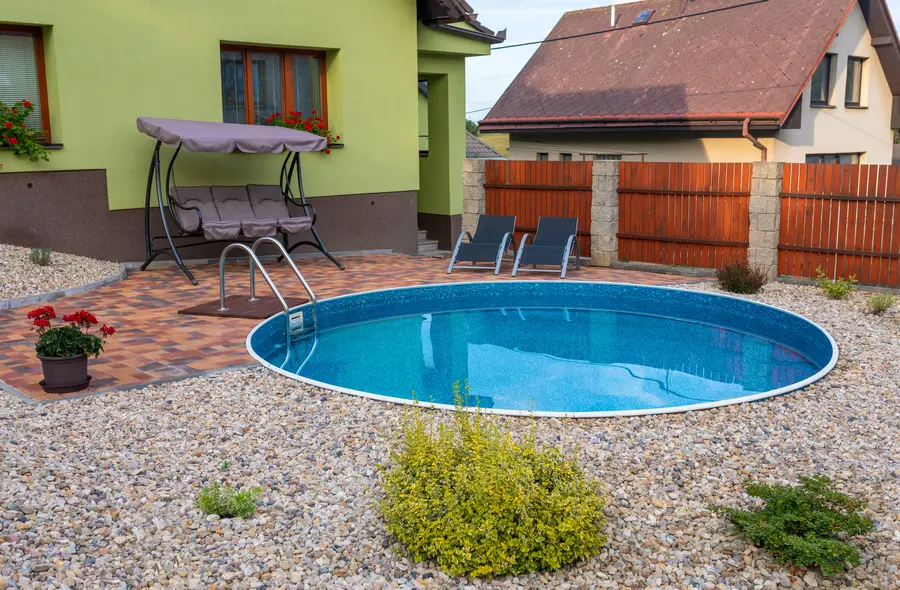 Gepflasterte Terrasse mit Pool und überdachtem Sitzplatz in einem Garten in Schalksmühle